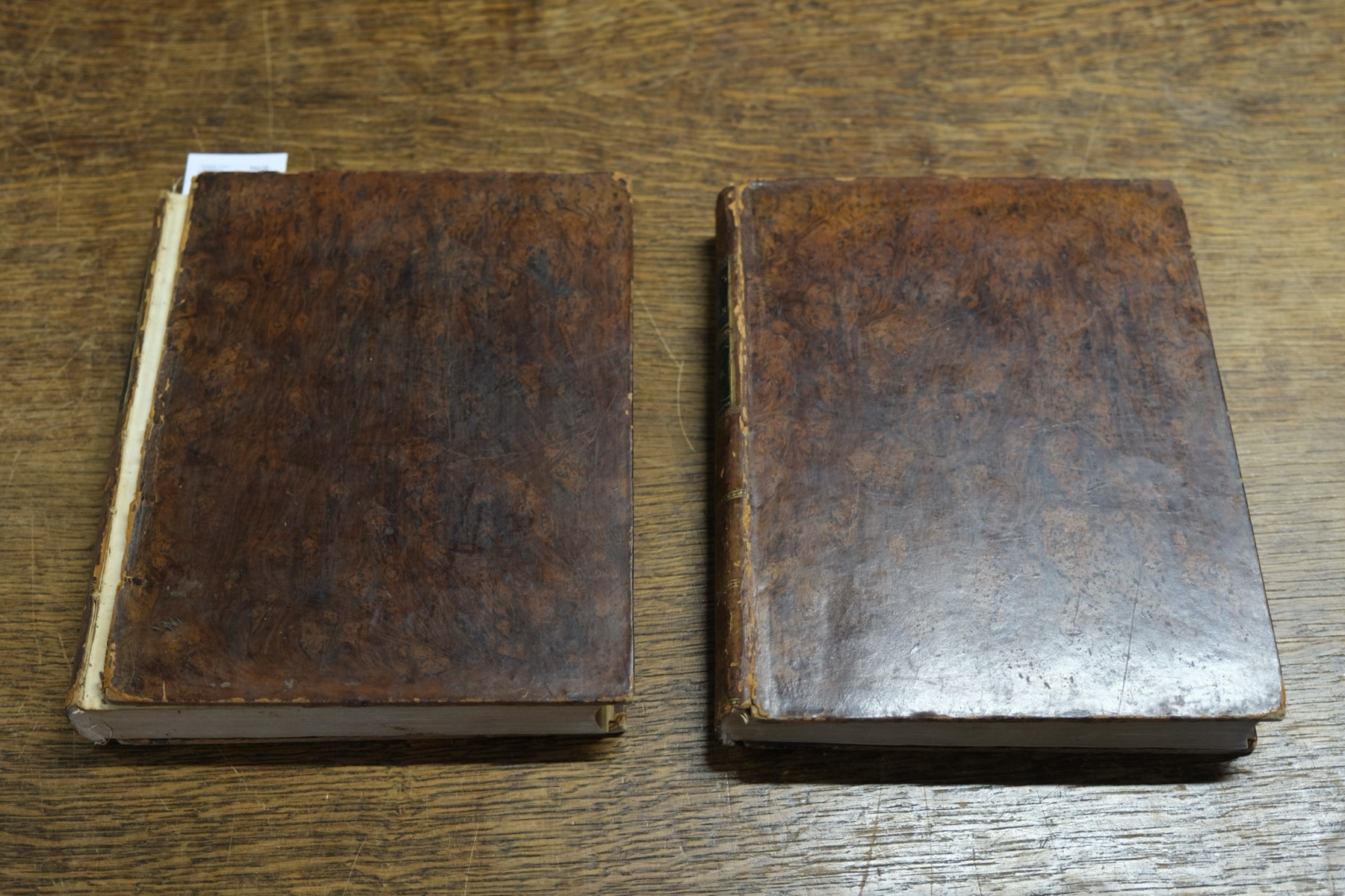 Volume I with its upper cover detached, volume II not far behind